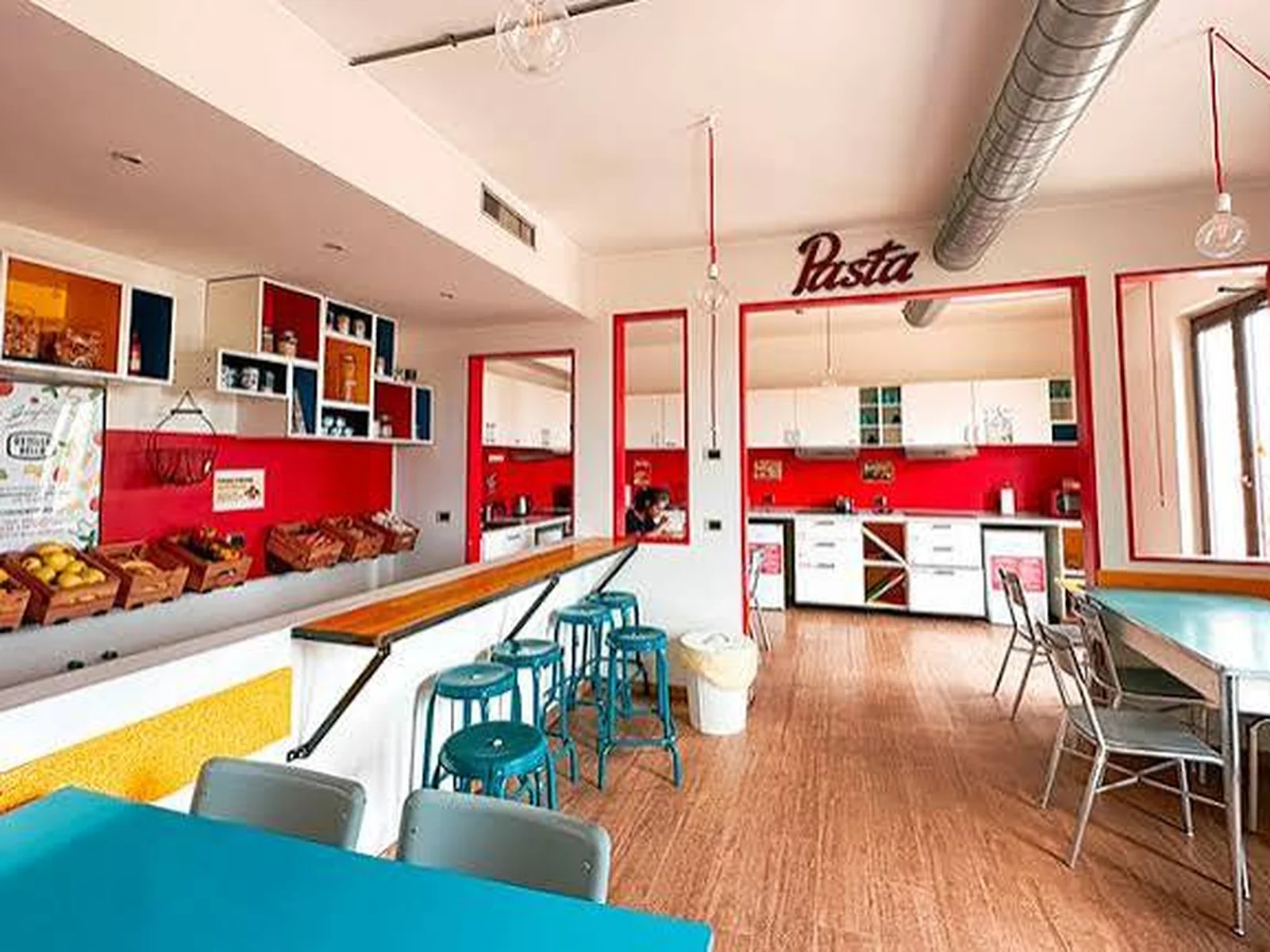 La cucina comune di Ostello Bello, con il bancone e le postazioni per gli ospiti